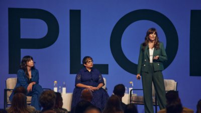 Indiana Matine, Senior Director of  Brand Planning no Expedia Group, no palco liderando uma apresentação ao lado de Amanda Rantuccio e Chandreyi Davis